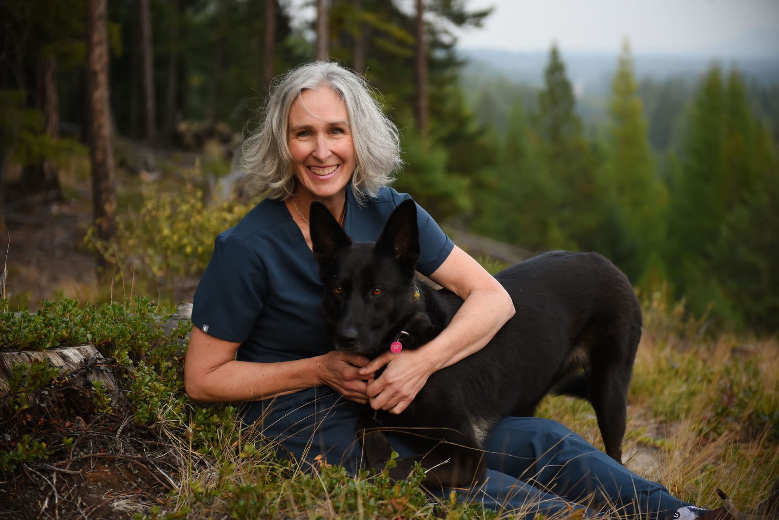 Portrait of Dr. Denise Lowing, DVM, with her dog in the East Kootenay
